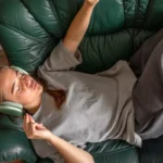 teenage girl lying couch listening music headphones listening music 683f55fbba1e3