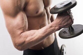 side view athletic man torso holding weights