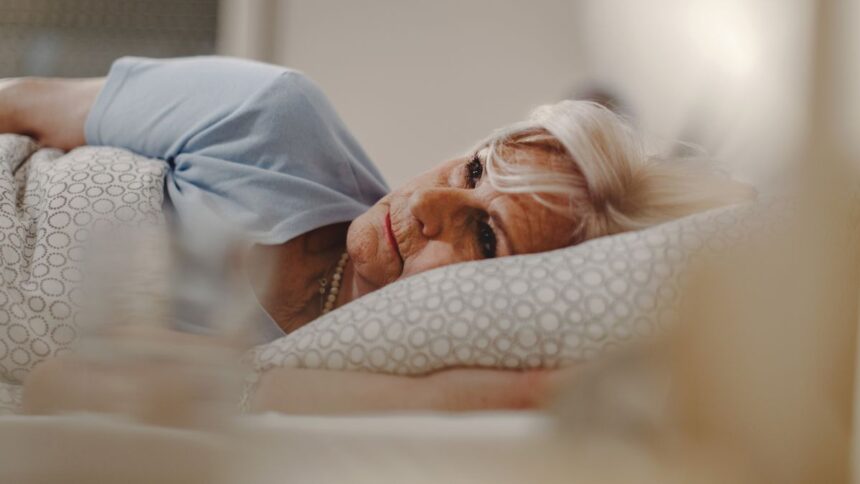 pensive senior woman lying bed thinking something