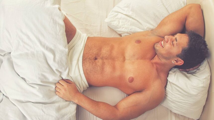 attractive man lying his bed smiling