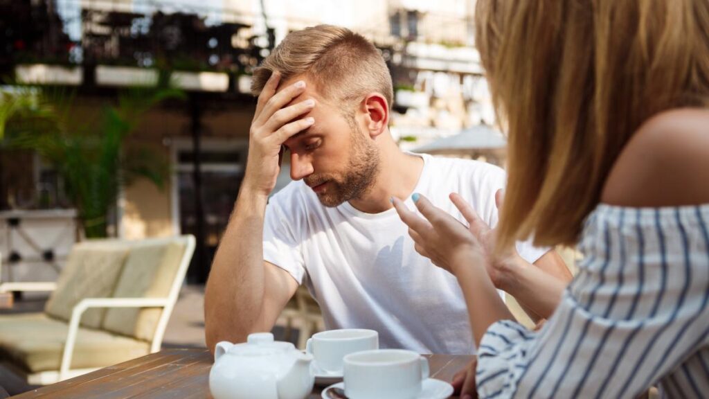 young beautiful couple quarreling sitting cafe