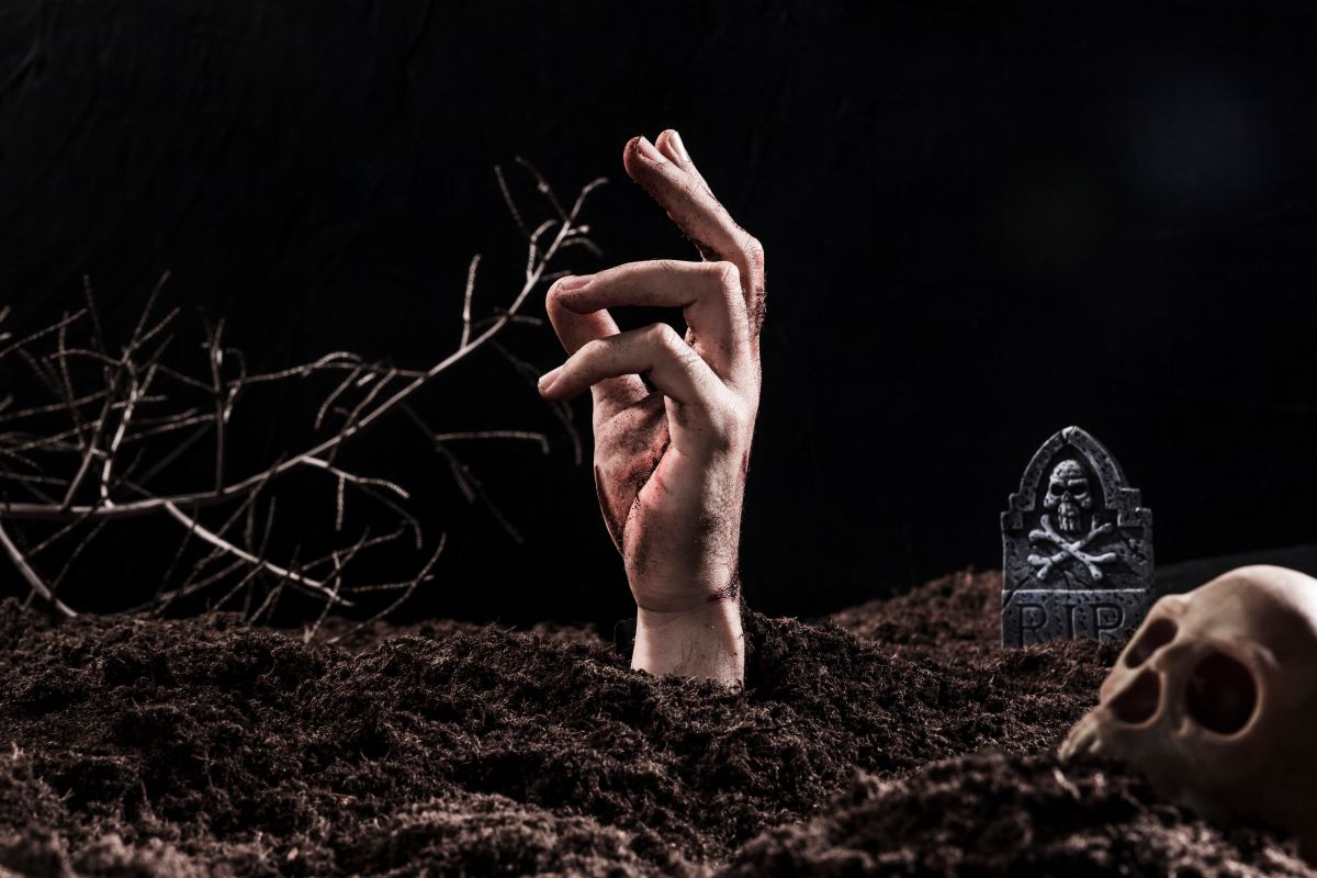 hand sticking out ground near skull